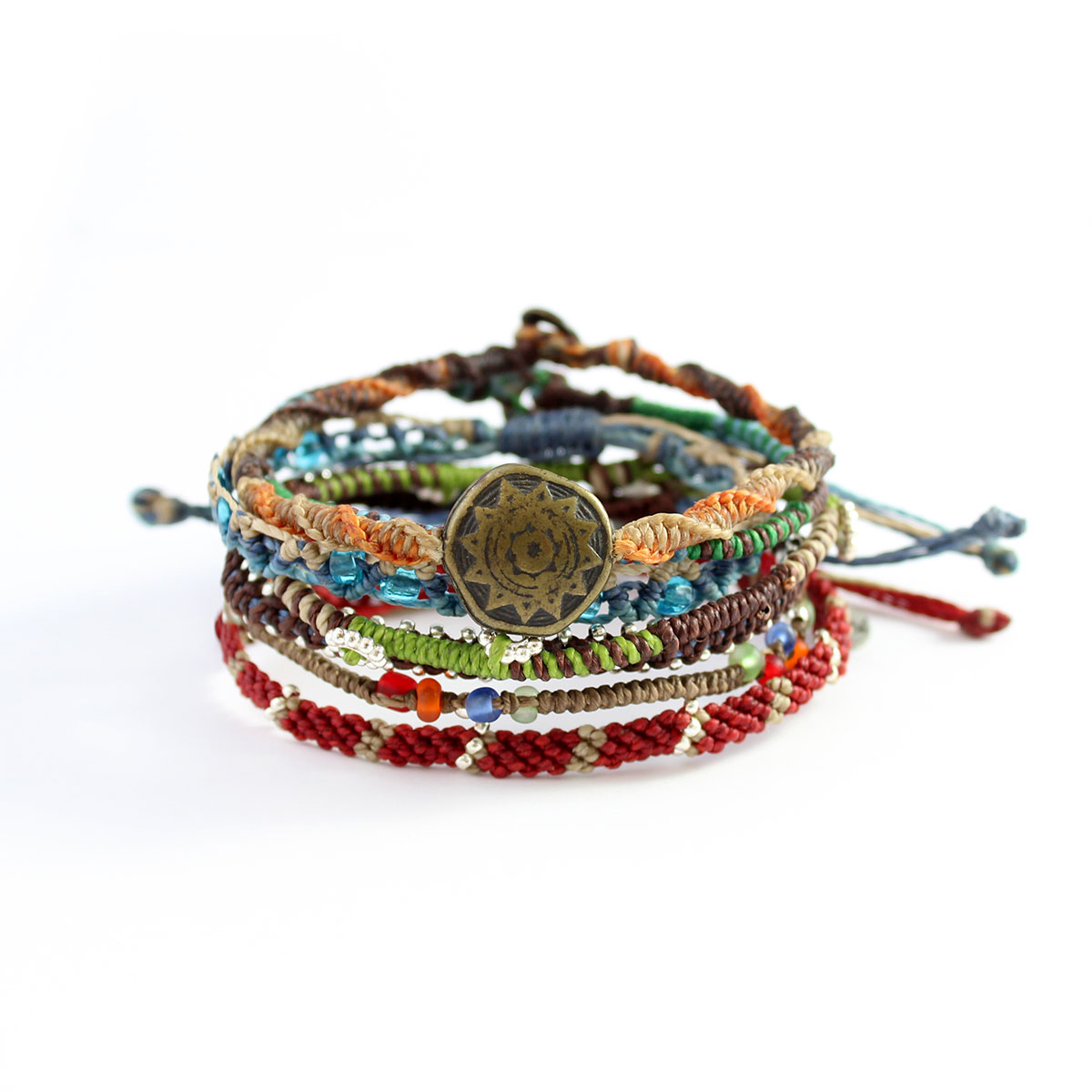 Colorful, intricately braided bracelets stacked together, with beads and a circular pendant.