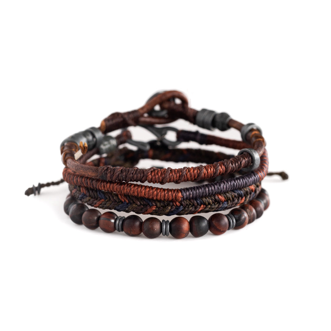 Colorful handmade woven bracelets with various beads and a central decorative bronze charm.